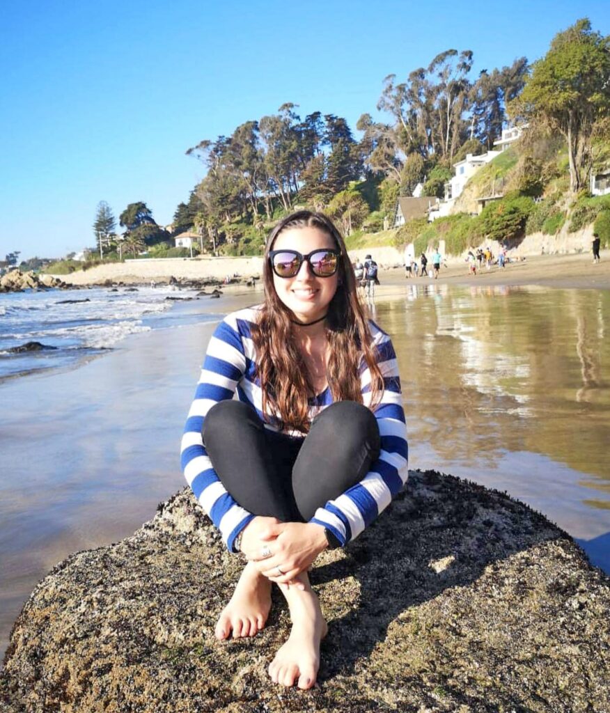 Das Bild zeigt Francesca, die auf einem Felsen am Playa Negra in Concón, Chile sitzt.
